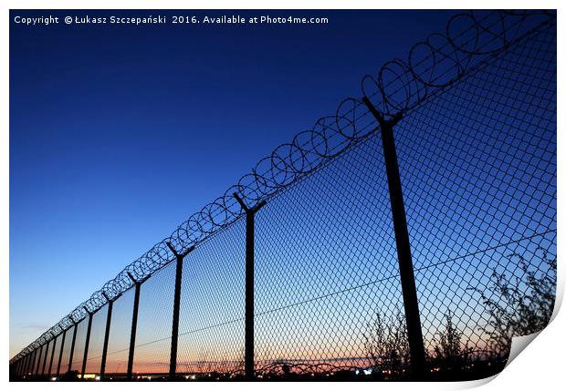 Restricted area fence against dark blue sky Print by Łukasz Szczepański