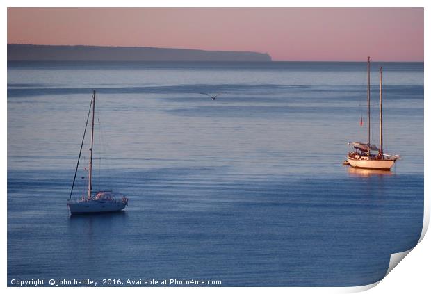 Pink Sky Sunrise flooding over boats on a calm blu Print by john hartley