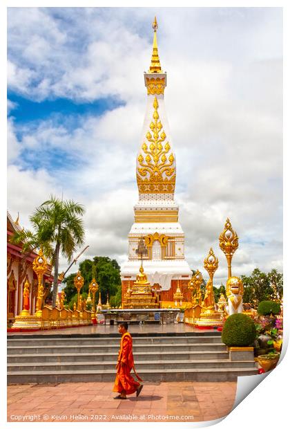 A monml walks past the spire in Wat Phra That Phanom Print by Kevin Hellon