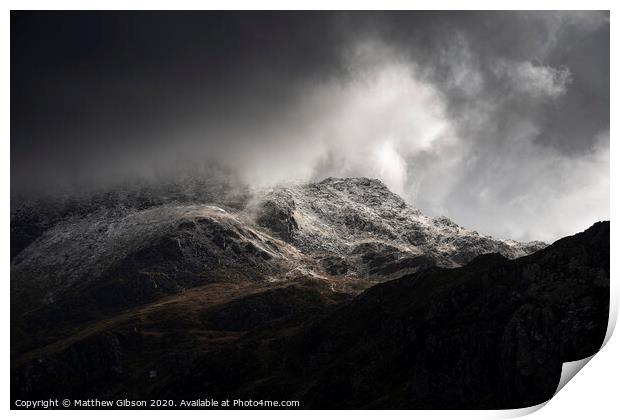 Stunning moody dramatic Winter landscape image of snowcapped Tryfan mountain in Snowdonia with stormy weather brooding overhead Print by Matthew Gibson