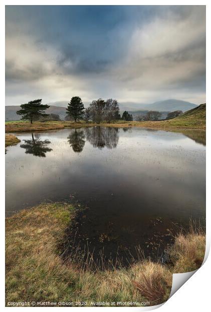 Stunning landscape image of dramatic storm clouds over Kelly Hall Tarn in Lake District during late Autumn Fall afternoon Print by Matthew Gibson