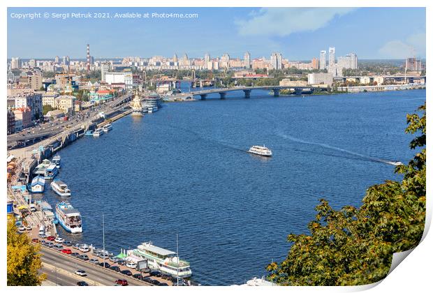 A landscape of summer Kyiv with a view of the Dnipro embankment in the old Podil district, a river station, piers, river trams and pleasure boats.30.08.20, Kyiv, Ukraine. Print by Sergii Petruk