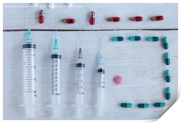 Medical syringes, capsules, pills lie vertically on a white roughly painted wooden table. Print by Sergii Petruk