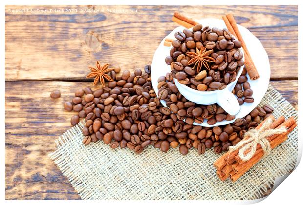 Grain coffee in a cup on a wooden background. Cinnamon on a napkin and tied with string. Anise stars complement the aroma of coffee. Print by Sergii Petruk