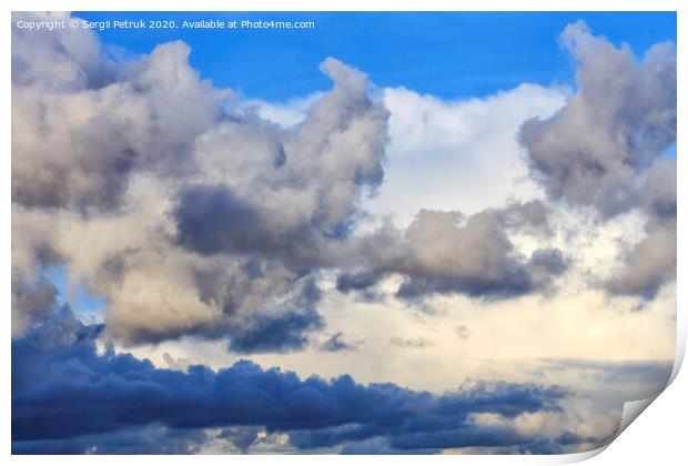 Storm clouds gather in a pile closing off a blue sky Print by Sergii Petruk