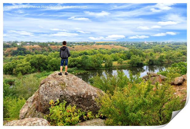A teenager stands on top of a large stone boulder on the banks of the Southern Bug and looks into the distance. Print by Sergii Petruk