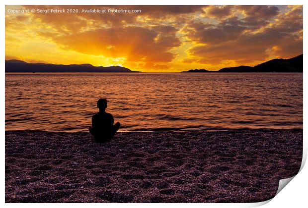 Silhouette of a teenager who sits on a pebble sea shore and watches a beautiful, vibrant sunset on the Gulf of Corinth in Greece. Print by Sergii Petruk