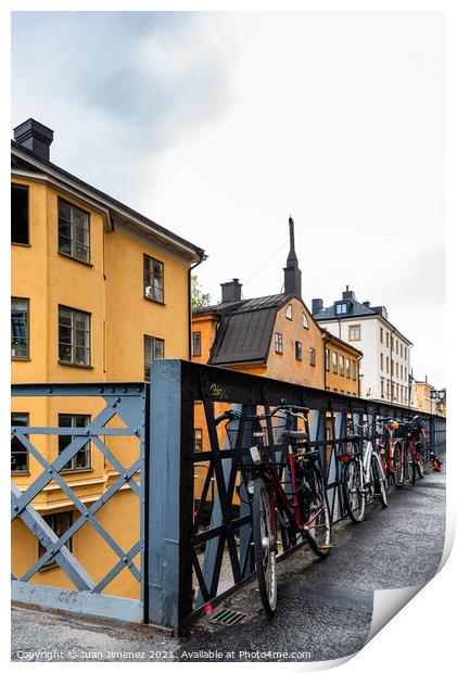 Bicycles parked in the street with colorful houses in Sodermalm  Print by Juan Jimenez