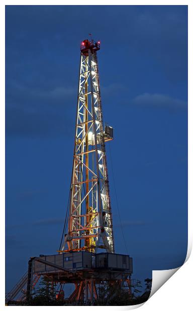 illuminated oil drilling rig on oilfield Print by goce risteski