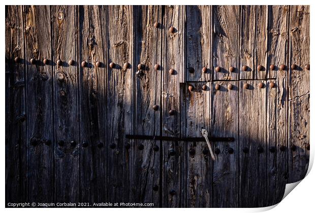 Old and decrepit wooden gate, half lit by the sun, in an unpopul Print by Joaquin Corbalan