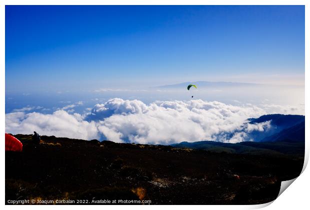 Paragliding above mountain peaks and white clouds during winter  Print by Joaquin Corbalan