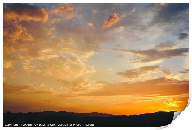 Beautiful sunset with the sun of orange tones behind the mountains and deep blue sky Print by Joaquin Corbalan
