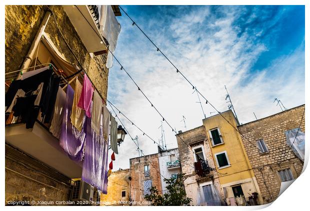 Colorful clothes tended to dry on the balconies of the old houses of an Italian city in the Mediterranean. Print by Joaquin Corbalan