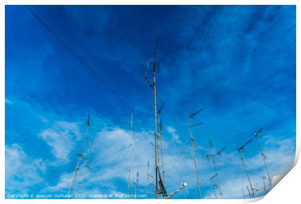 Television antennas on the roof of an old building with dramatic sky. Print by Joaquin Corbalan