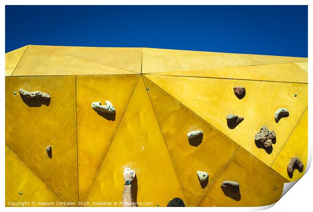 Young man grabs to try climbing on an outdoor climbing wall in a park in Valencia. Print by Joaquin Corbalan