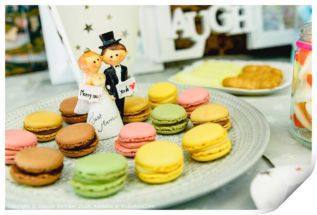 Happy newlywed dolls on a plate with macarons in the candy bar of a wedding. Print by Joaquin Corbalan