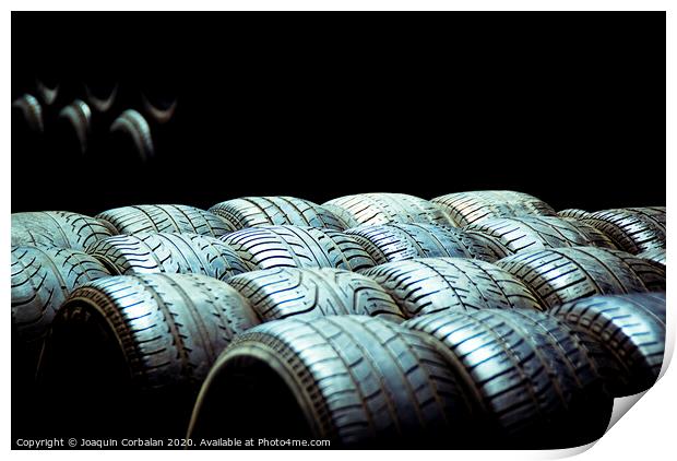 Old tires and racing wheels stacked in the sun Print by Joaquin Corbalan