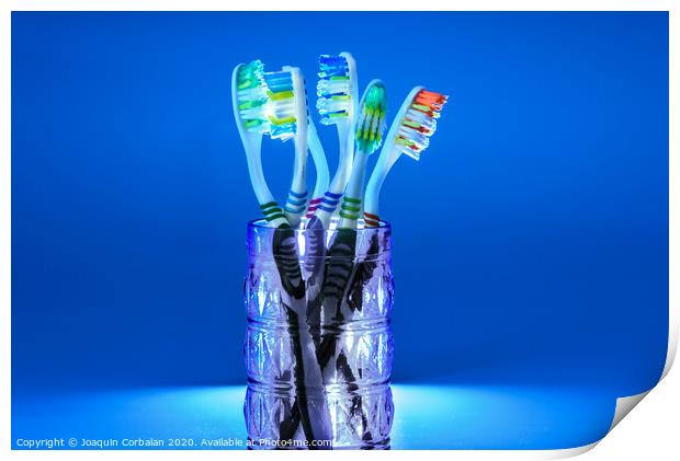 Many new plastic toothbrushes inside a glass, isolated on striking blue background, with copy space. Print by Joaquin Corbalan