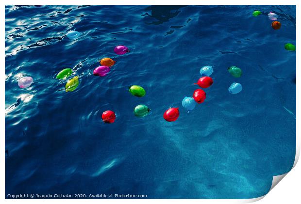 Colorful plastic water balloons floating in a pool to play on vacation to cool off. Print by Joaquin Corbalan