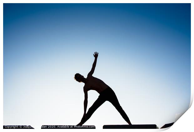 Silhouette of a man practicing yoga, isolated against the blue sky. Print by Joaquin Corbalan