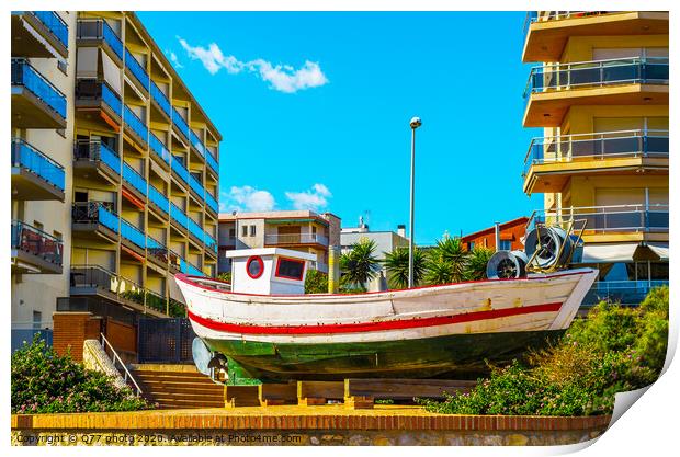 view of the promenade in the seaside town, in the middle of the roundabout old fishing boat Print by Q77 photo