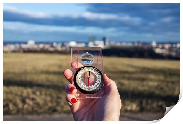 Female hand holding glass compass, nature in backg Print by Josef Kubes