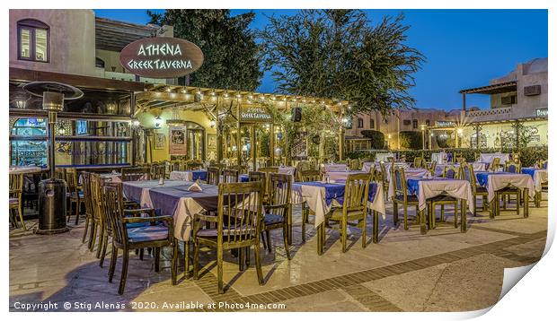 illuminated greek taverna with tables and chairs i Print by Stig Alenäs