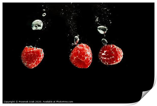 Raspberries splashing into clear water isolated on black background. Print by Przemek Iciak