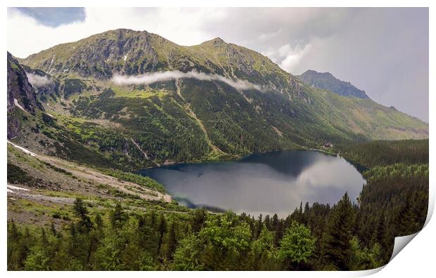 Wide angle top view of Morskie Oko naturally formed lake pond in Tatra Mountains in Poland. High mountain landscape with dramatic clouds covered with snow and trees at national park High Tatras Europe Print by Arpan Bhatia