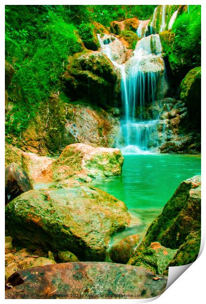 A waterfall flowing over rocks into a lake. Print by Hanif Setiawan