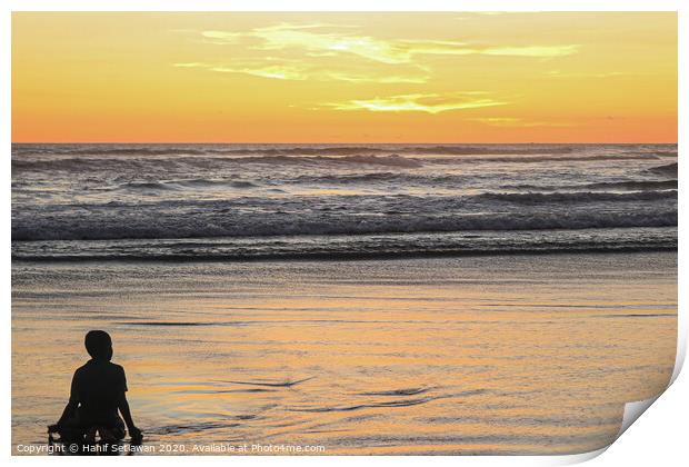 A young boy on wet sand beach at sunset. Print by Hanif Setiawan