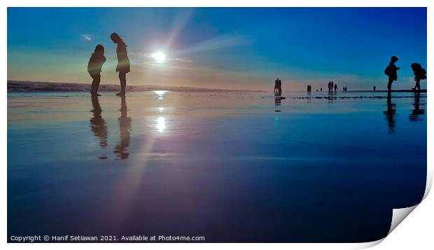 Silhouetted people in a row on a wet sand beach. Print by Hanif Setiawan