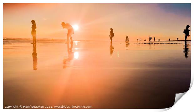 Silhouetted people in a row on a wet sand beach. Print by Hanif Setiawan