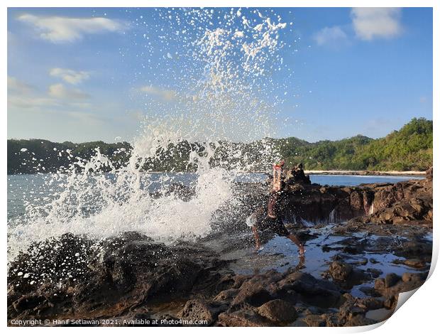 A big wave hits a man on a rock plateau Print by Hanif Setiawan