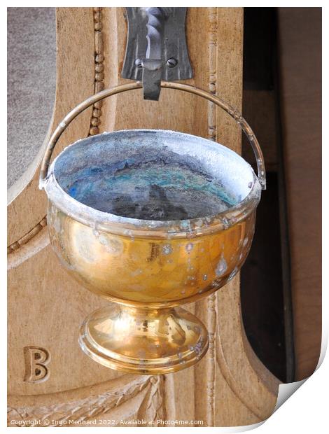 A vertical shot of an old golden goblet hung from a metal hook in the church Print by Ingo Menhard