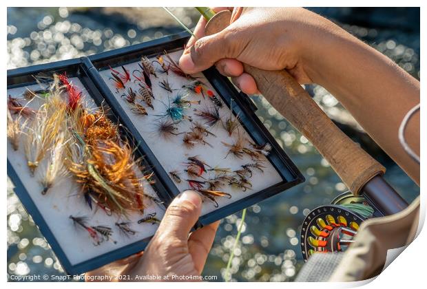 A close up of an asian female selecting fly fishing flies from a box Print by SnapT Photography