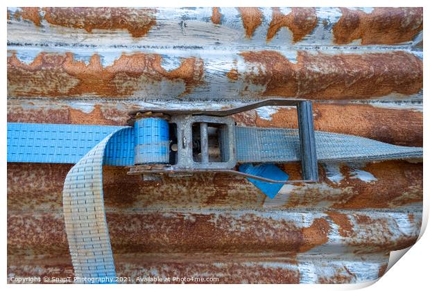 A blue rachet strap wrapped around a rusty corrugated iron metal sheet Print by SnapT Photography