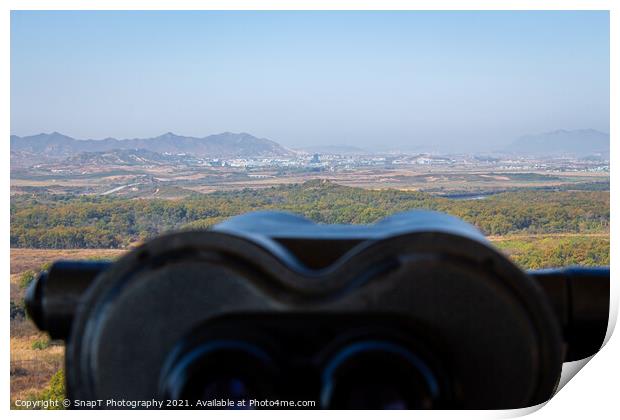 A view into North Korea across the DMZ from South Korea, from behind binoculars Print by SnapT Photography