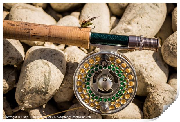 A close up of a trout fly rod, reel and line on rocks, with a cicada fly Print by SnapT Photography