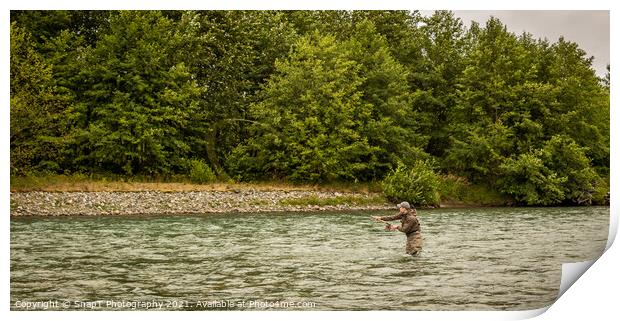 A fly fisherman spey casting while wading in a fast flowing, green, glacial river. Print by SnapT Photography
