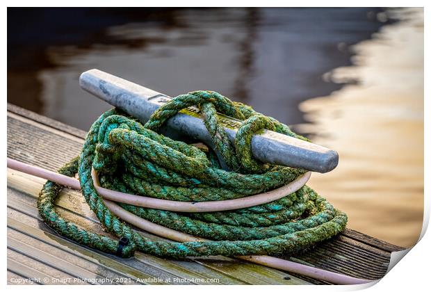 Rope tied around a metal bollard mooring on a wooden jetty Print by SnapT Photography