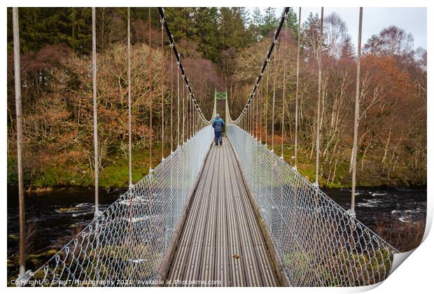 Man walking over an old wooden suspension bridge across a river in Scotland Print by SnapT Photography