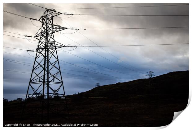 Electricity pylons in a field on a cloudy day in w Print by SnapT Photography