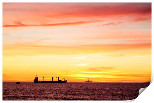 Sunset over ships waiting to enter Cape Town Harbour, South Africa Print by Neil Overy