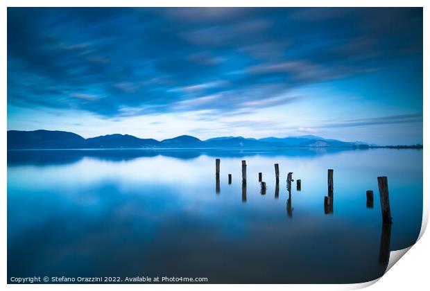 Remains of a wooden jetty in a blue lake Print by Stefano Orazzini