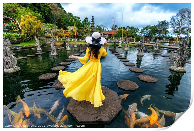 Woman standing in pond with colorful fish at Tirta Gangga Water  Print by Stan Lihai