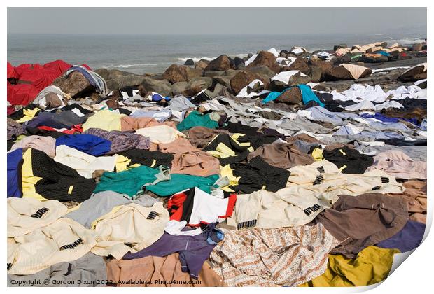 Freshly laundered clothes and fabrics drying on rocks by the sea at Mumbai, India Print by Gordon Dixon