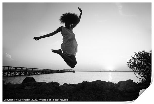 African American woman jumping by ocean at sunset Print by Spotmatik 