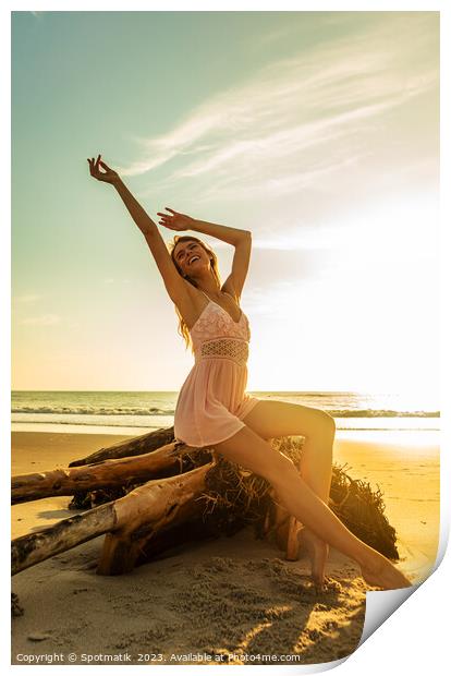 Carefree Bohemian girl sitting on driftwood at sunset Print by Spotmatik 