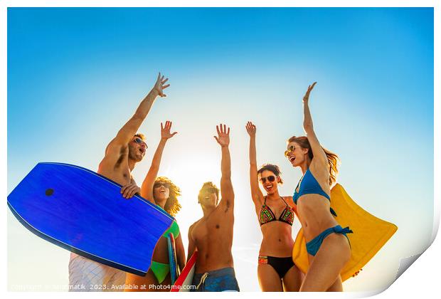 Friends in swimwear carrying bodyboards celebrating fun activity Print by Spotmatik 